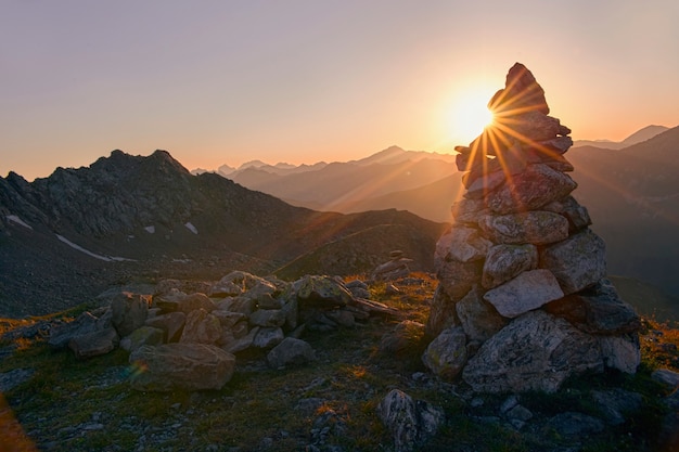 Nascer do sol no alto das montanhas, um cenário fabuloso. Os raios do sol brilham por trás das montanhas. Viagem pelos picos das montanhas do Cáucaso. Arkhyz