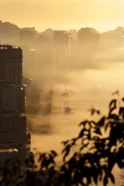 Nascer do sol no mirante da falésia com a praia do Leblon ao fundo sobre densa neblina no Rio de Janeiro