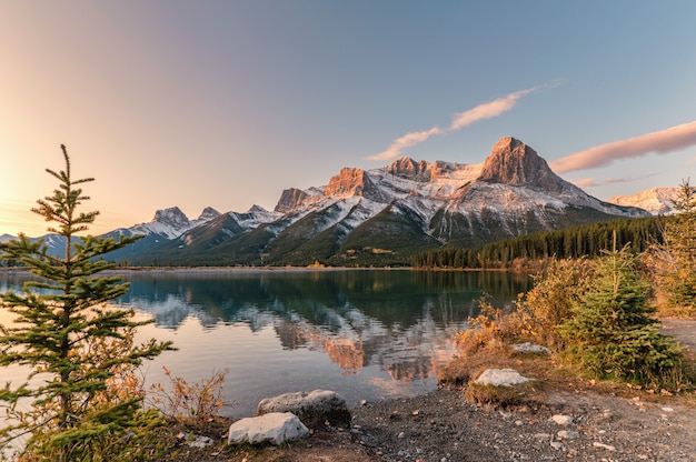 Nascer do sol no Monte Rundle com reflexo do céu colorido no reservatório de Rundle Forebay no outono em Canmore