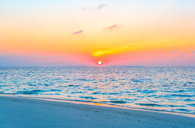 Nascer do sol pitoresco na ilha das maldivas, o sol nascendo do oceano índico e refletido no conceito de viagem de água