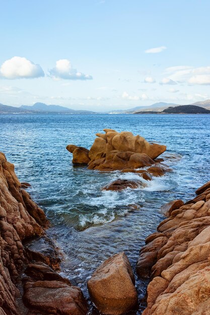 Nascer do sol romântico da manhã na praia de Capriccioli de Costa Smeralda, no mar Mediterrâneo, na ilha da Sardenha, na Itália. Céu com nuvens. Pedras e rochas.