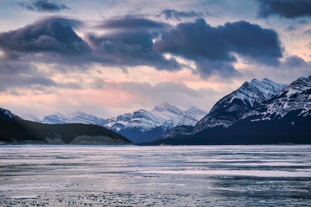 Nascer do sol sobre montanhas rochosas e lago congelado em Abraham Lake no Parque Nacional Jasper