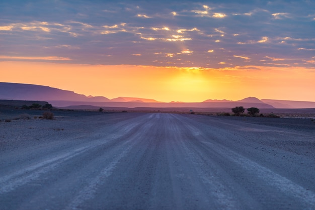 Nascer do sol sobre o deserto de namib, roadtrip no parque nacional maravilhoso de namib naukluft, destino do curso em namíbia, áfrica. luz da manhã, névoa e nevoeiro, aventura fora da estrada.