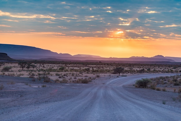 Nascer do sol sobre o deserto de Namib, roadtrip no parque nacional maravilhoso de Namib Naukluft, destino do curso em Namíbia, África. Luz da manhã, névoa e nevoeiro, aventura fora da estrada.