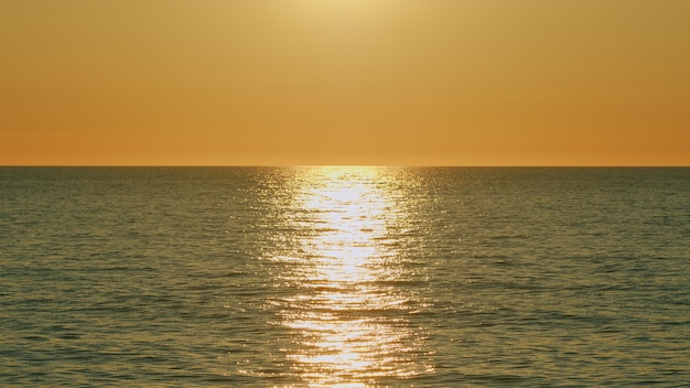 Nascer do sol sobre o mar calmo ondas do oceano movimento relaxante no vermelho laranja luz do sol cópia do espaço movimento lento