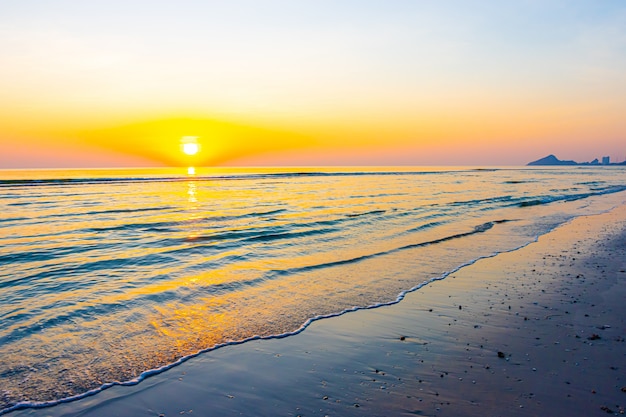 Nascer ou pôr do sol com céu crepuscular e praia do mar