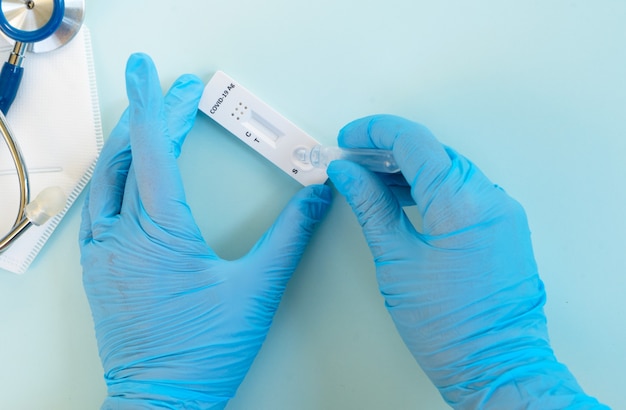 Nasenantigen-Covid-19-Test, Krankenschwester in blauen Handschuhen führt Covid-19-Test durch