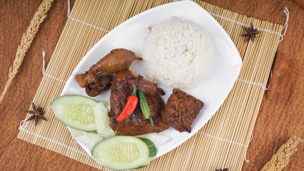 Nasi Ayam Bakar es una comida javanesa hecha de pollo a la parrilla con arroz servido en un plato blanco