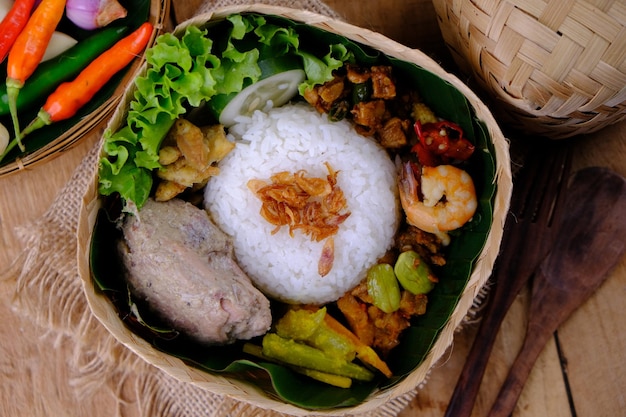 Nasi Berkat Pekalongan. es arroz con guarniciones de pollo frito, verduras picantes salteadas.