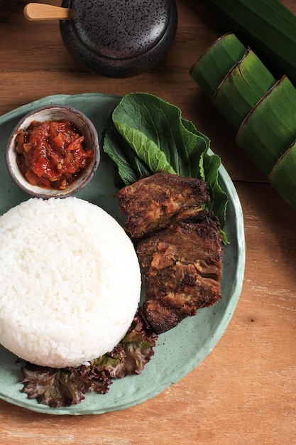 Nasi Empal o Gepuk es carne frita de Indonesia, cocinada en leche de coco con hierbas y especias. Sabroso, tierno y delicioso. Por lo general, se sirve con Sambal, arroz y ensalada.