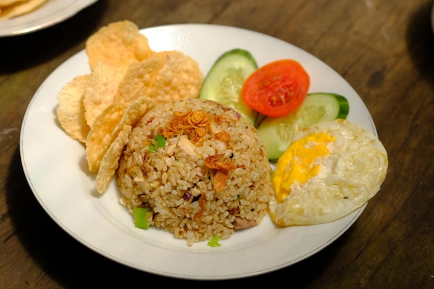 Nasi Goreng. arroz frito con huevo soleado, chips de yuca, rodajas de pepino y tomate. telur ceplok.