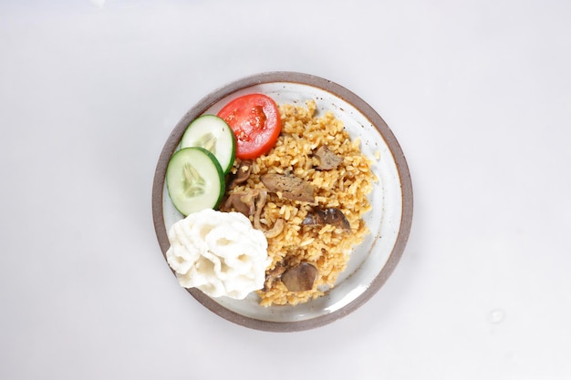 Nasi Goreng Hati Ampela ist gebratener Reis mit Hühnermagenherz, garniert mit frischer Gurke.