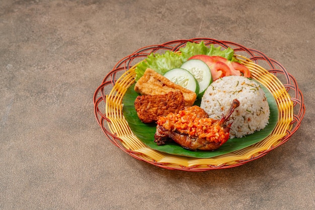 Nasi Jeruk Ayam Geprek es una comida indonesia de pollo frito crujiente con sambal bawang caliente y picante