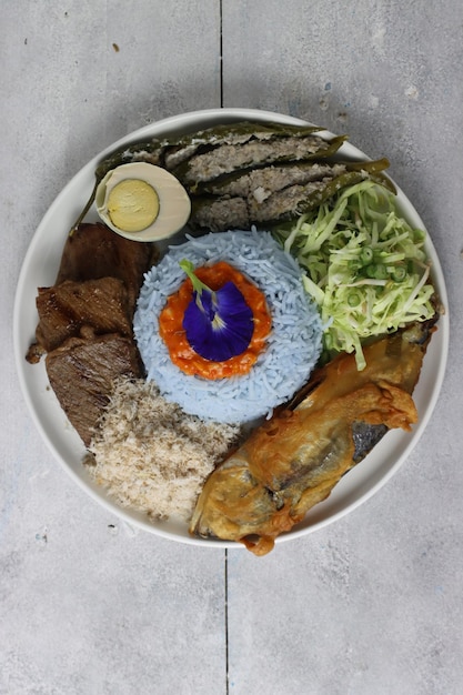 Nasi kerabu kelantan plato tradicional de arroz malayo consiste en carne pescado sal huevo y verduras