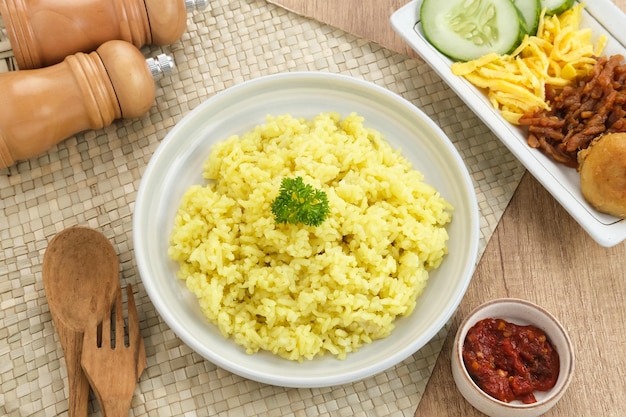 Nasi kuning, comida tradicional indonésia, feita de arroz cozido com açafrão e leite de coco