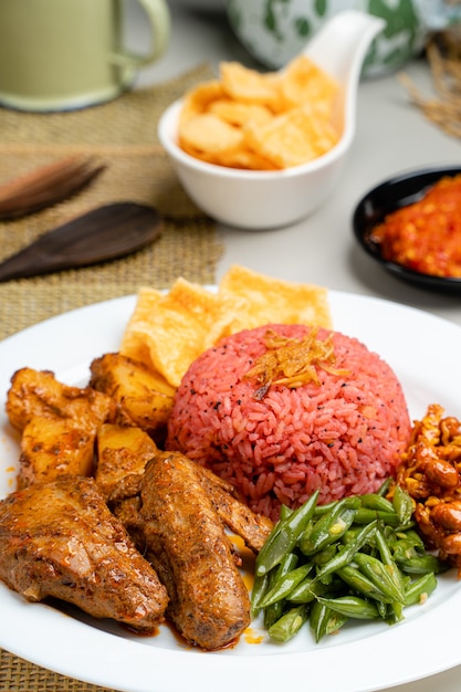 Nasi lemak com arroz de fruta do dragão servido com frango rendang e molho picante de sambal