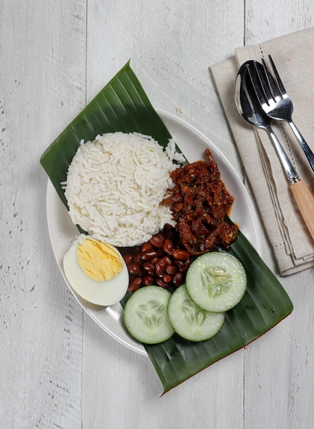 Nasi lemak, un plato tradicional de arroz con pasta de curry malayo servido con una guarnición variada