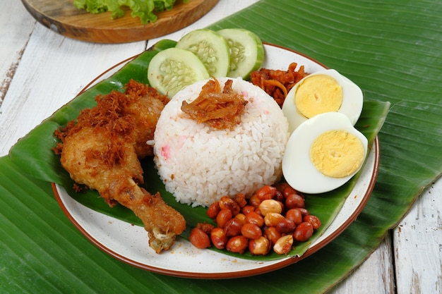 Foto nasi lemak, prato de arroz perfumado malaio cozido em leite de coco e folha de pandan servido com vários sid