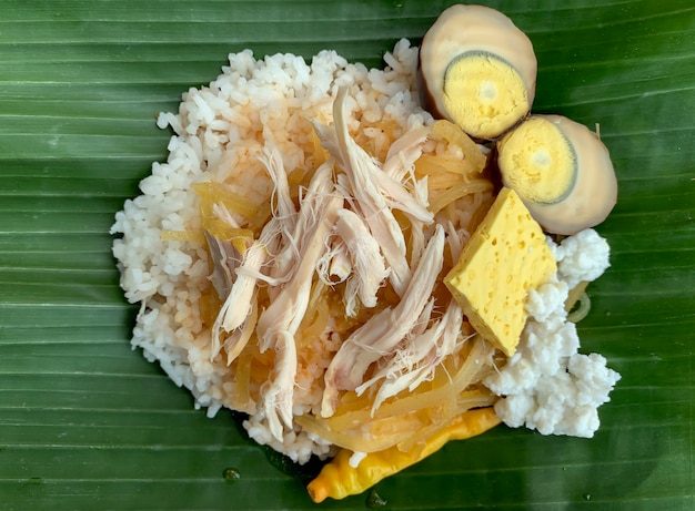 Nasi Liwet Solo, um alimento tradicional de Surakarta, Indonésia, saboroso arroz cozido no vapor com curry de frango desfiado e ovo de galinha