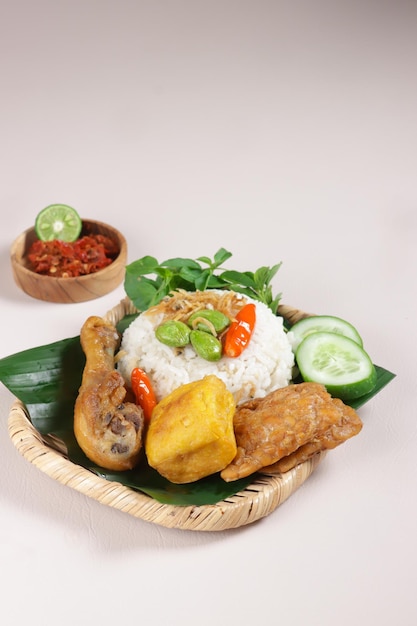 Nasi Liwet Sunda Arroz sundanés tradicional servido con pollo frito, tofu, anchoas tempeh