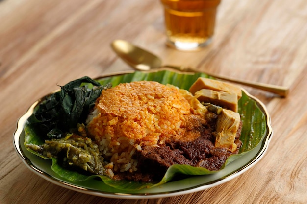 Nasi Padang se originó en Indonesia Arroz con carne Rendang hojas de mandioca Gulai Nangka y Sambal servido en hoja de plátano