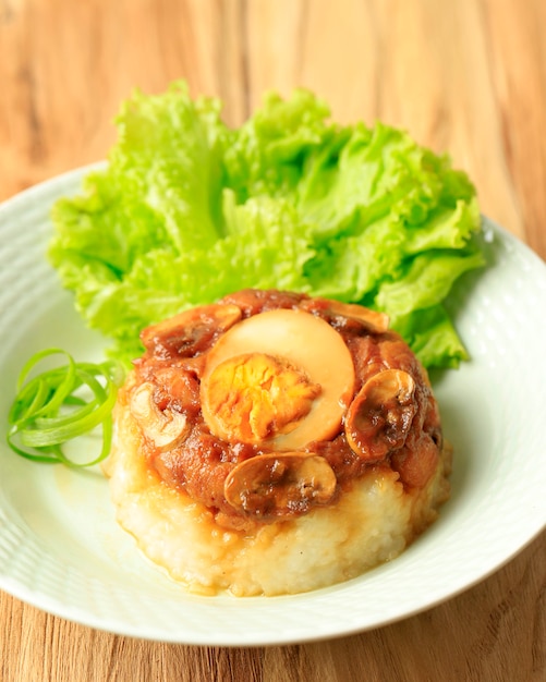 Nasi Tim Ayam casero, arroz al vapor con salsa de pollo y soja en cubitos. Comida reconfortante de Indonesia para el desayuno. Servido en plato de cerámica con espacio para copiar texto