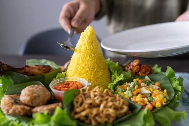 Nasi Tumpeng indonesische Küche gelber Reis auf Bananenblatt