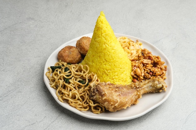 Nasi Tumpeng oder Nasi Kuning ist ein kegelförmiger Reis mit verschiedenen Beilagen