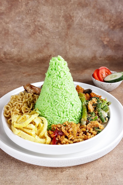 Nasi Tumpeng Pandan ist ein kuppelförmiger grüner Pandan-Reis mit verschiedenen Beilagen