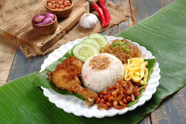 Foto nasi uduk betawi, plato de arroz al vapor con sabor a coco de betawi, yakarta. se sirve con varios platos.