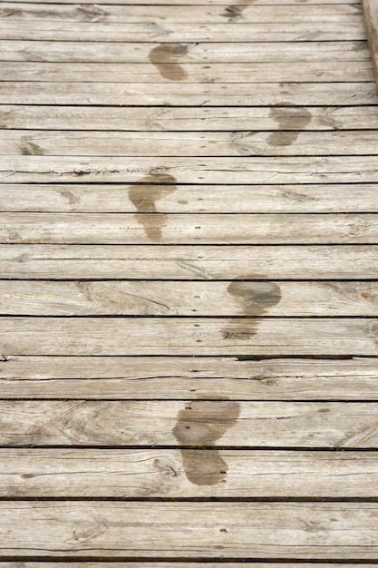 Nasse menschliche Fußabdrücke auf Holzbohlen