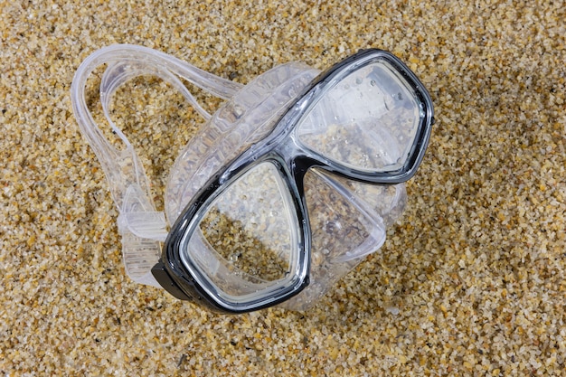 Nasse Tauchmaske über einem Strandsand. Sommersport und Freizeit.