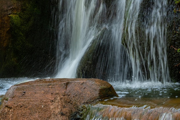 Nasser Felsbrocken in der Mitte der Wasserfalldüsen