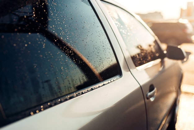 Foto nasses autofenster nach der nahaufnahme. autowaschstation. auto reinigen