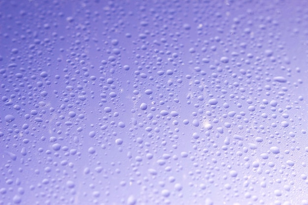 nasses Fensterglas mit Wassertropfen und blauem Himmel