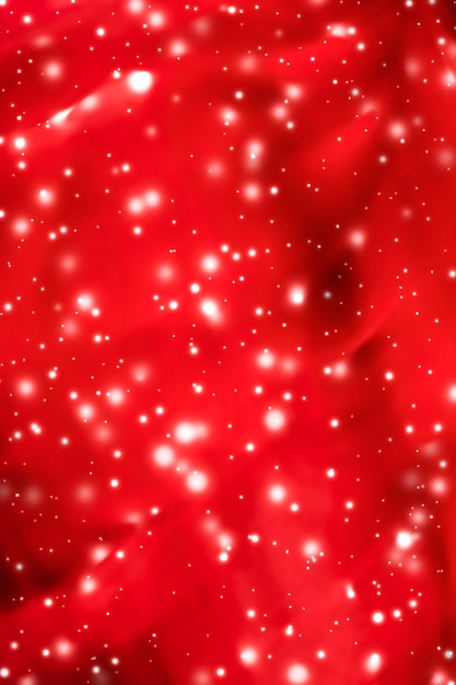 Foto natal, ano novo e dia dos namorados, fundo abstrato vermelho, design de cartão de férias, brilho de neve brilhante como pano de fundo de venda de temporada de inverno para marca de beleza de luxo