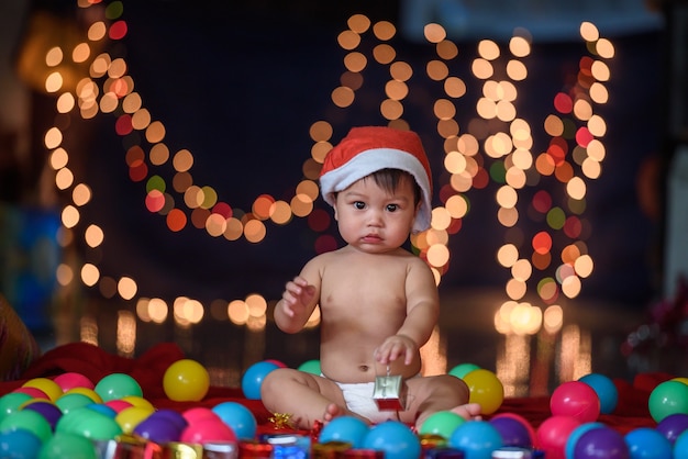 Foto natal, bebê, sentando, um, pele, segurando, um, caixa presente, perto, um, ano novo, abeto árvore, e, um, presente, bo