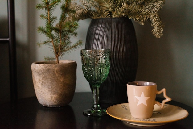 Natal bege ou copo verde de inverno sobre a mesa ao lado de um vaso e ramos de abeto