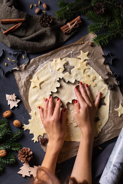 Natal cozinhando e assando mãos femininas fazendo biscoitos de massa