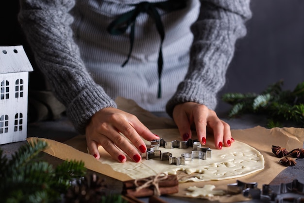 Natal cozinhando e assando mãos femininas fazendo biscoitos de massa