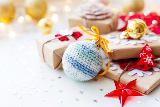 Natal e ano novo com bola artesanal de malha, presentes e decorações para árvore de Natal. Férias com confetes de estrelas e lâmpadas. .