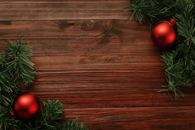 Foto natal e ano novo com decoração de bolas vermelhas na vista superior do fundo da mesa de madeira com espaço de cópia.