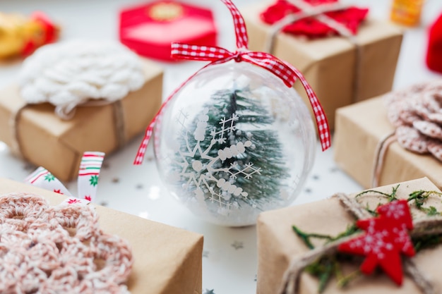 Natal e ano novo com presentes, decorações e bola decorativa com abeto dentro.