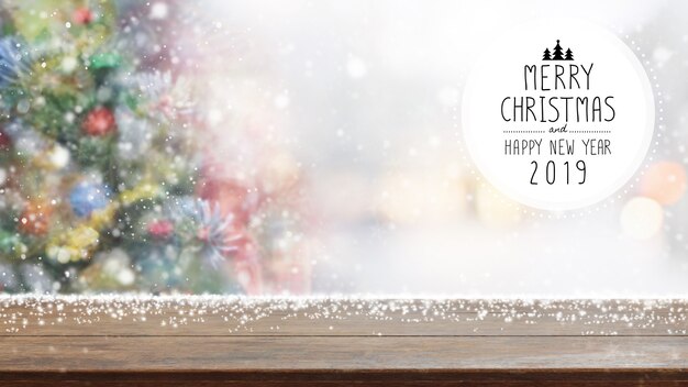 Natal e ano novo feliz 2019 no tampo da mesa de madeira vazio na árvore de Natal do bokeh do borrão.