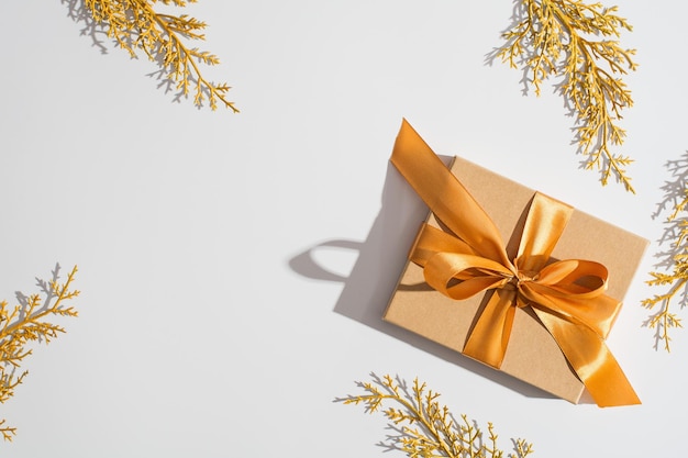 Natal e feliz ano novo conceito de celebração de ouro e branco com caixa de presentes e ramo dourado Sombra do sol