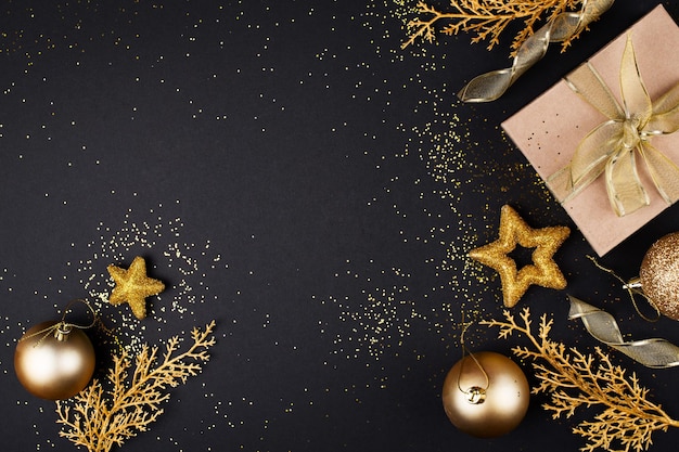 Natal e feliz ano novo conceito de celebração de ouro e preto com caixa de presente e decoração Copiar espaço
