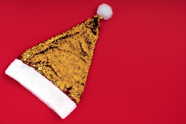 Natal espumante chapéu de Papai Noel dourado no vermelho. Fundo de férias do Natal Natal ano novo. Acessório de ano novo. Cartão de feliz Natal. Vista superior, plana leigos, copyspace