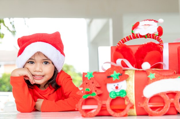 Natal, feriados e conceito de infância - menina sorridente com caixa de presente em casa