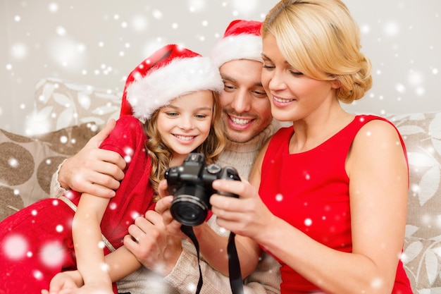 natal, feriados, tecnologia e conceito de pessoas - família feliz com câmera digital assistindo fotos em casa