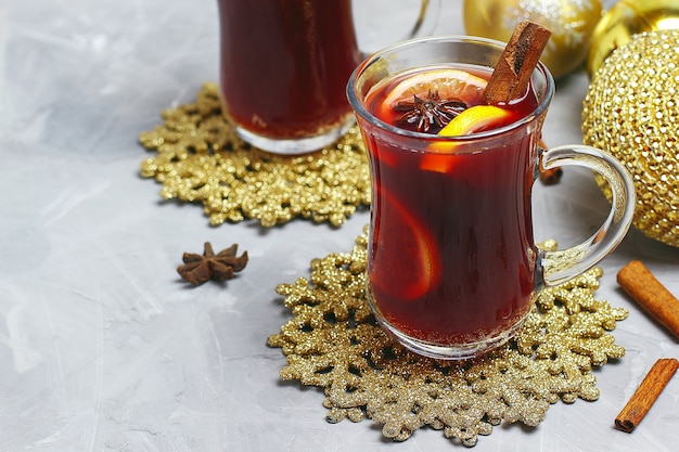 Natal mulled vinho com especiarias e rodelas de limão no concreto cinza